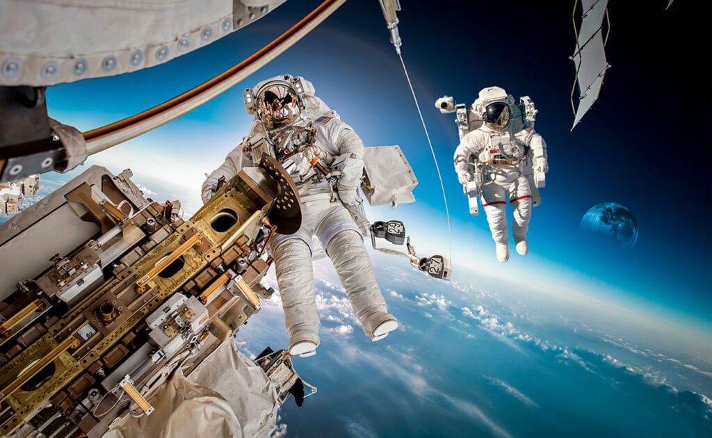 Astronautas no espaço com a Terra ao fundo