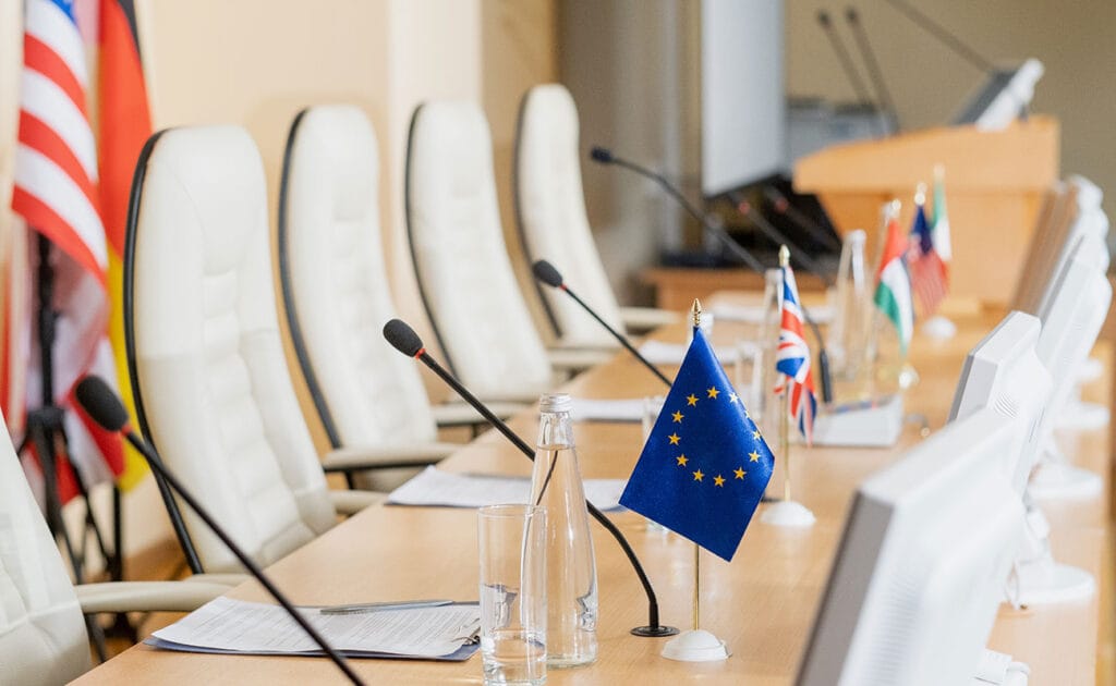 Mesa de conferência com microfones e bandeiras